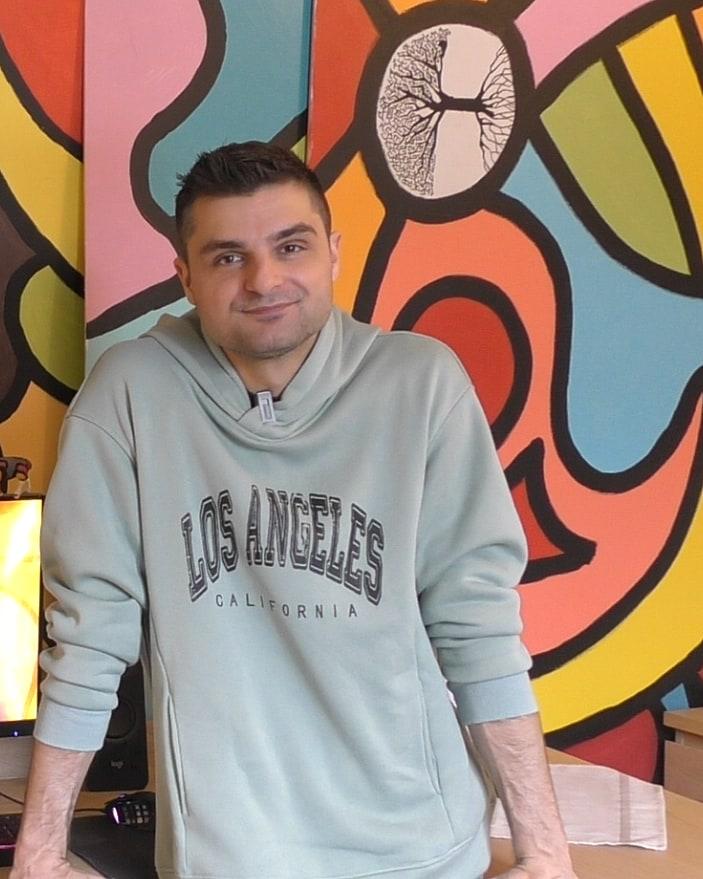 Rémi Barlet, debout dans son atelier, devant les toiles qu'il a peintes